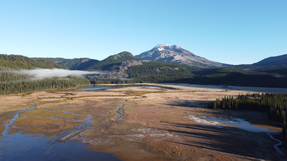 person standing on brown field near mountain under blue sky during daytime