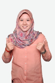woman in pink button up shirt wearing purple and white hijab