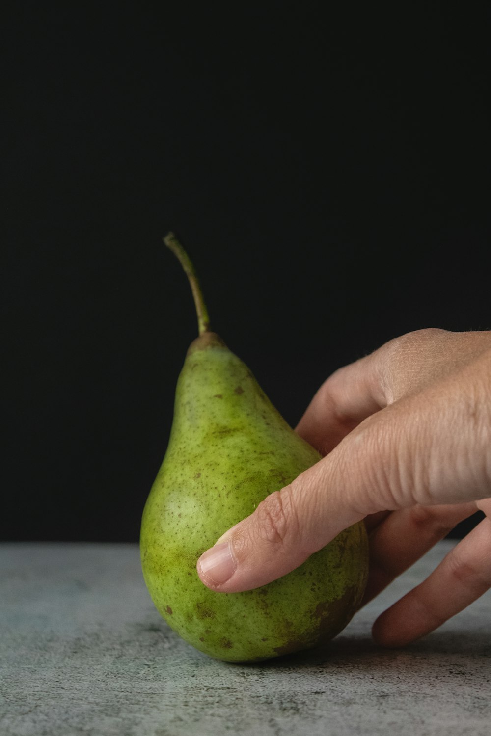 person holding green oval fruit
