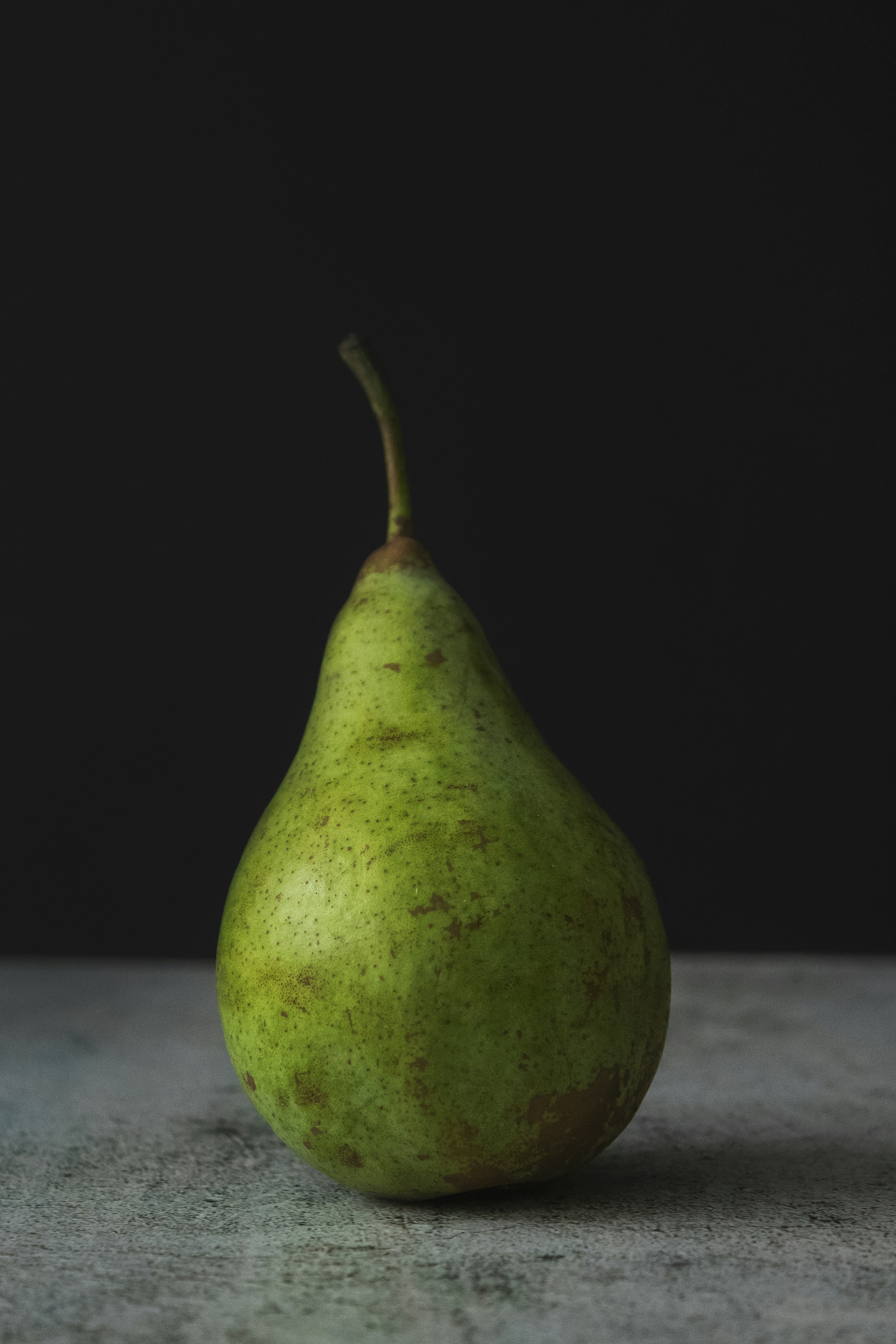 Green pear on dark background
