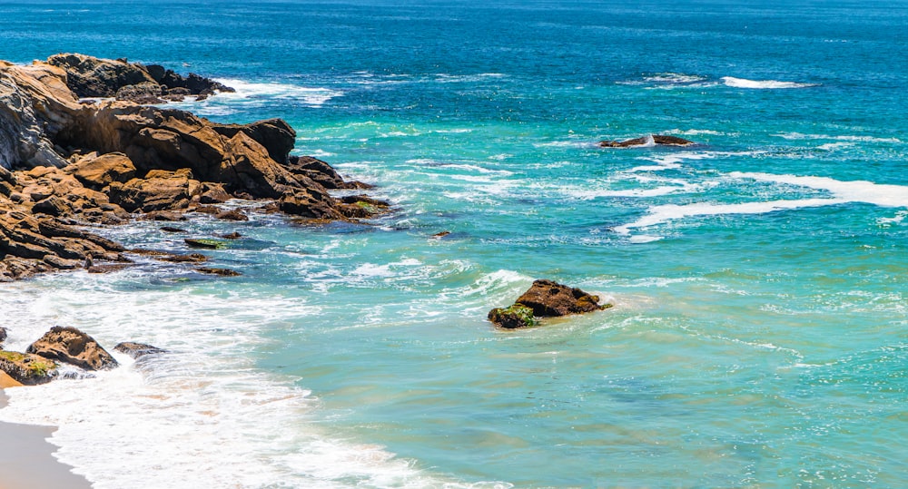 brown rock formation on sea water during daytime