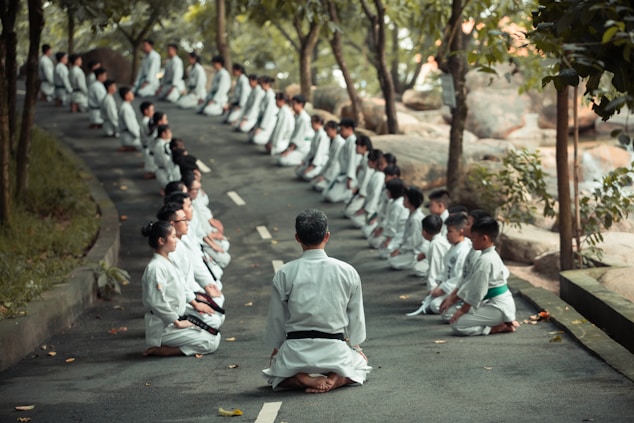 people in white uniform walking on road during daytime