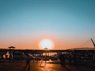 A vibrant sunset over a quaint Vancouver Island harbor with fishing boats gently bobbing in the water.