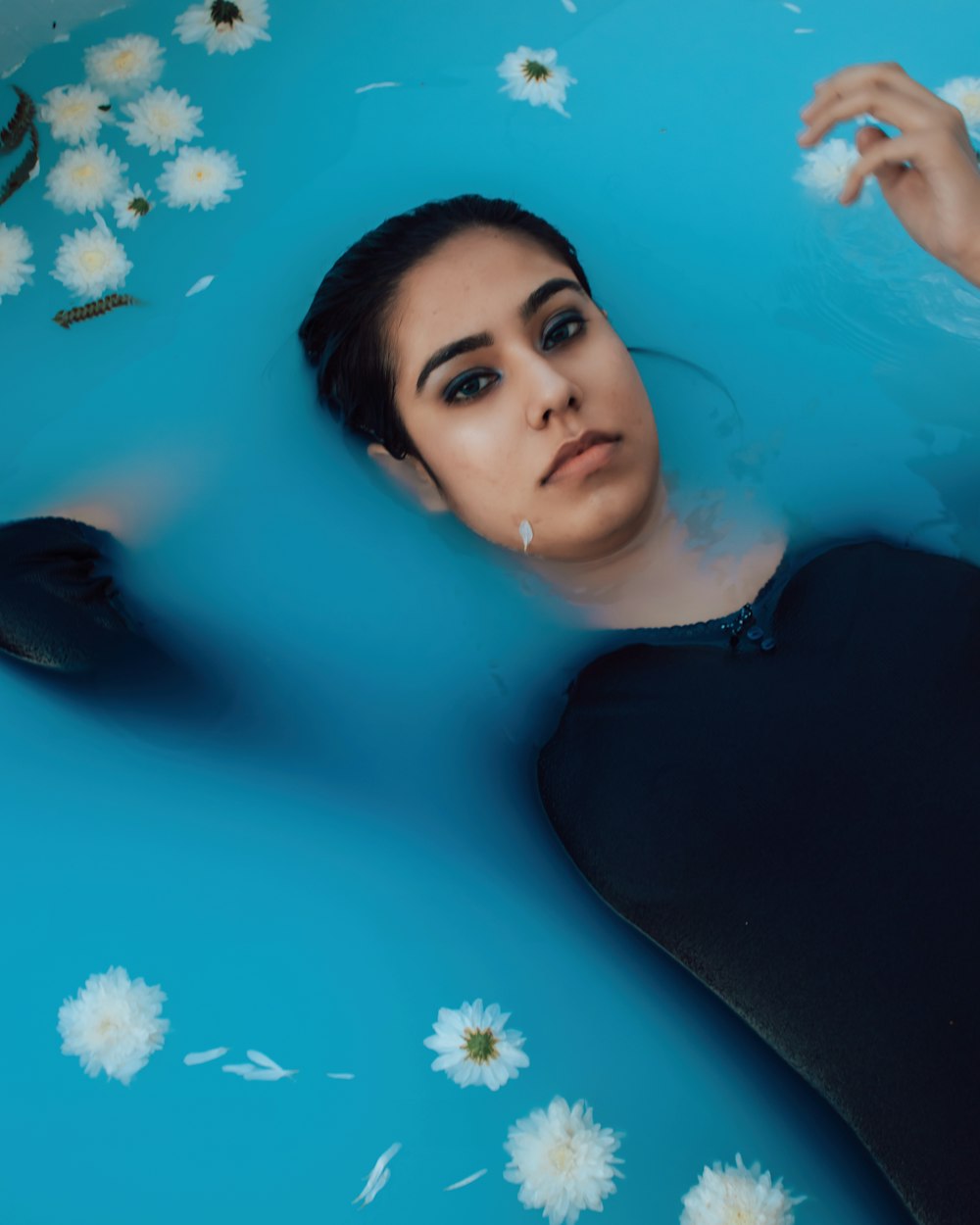 woman in black long sleeve shirt in water with blue flowers