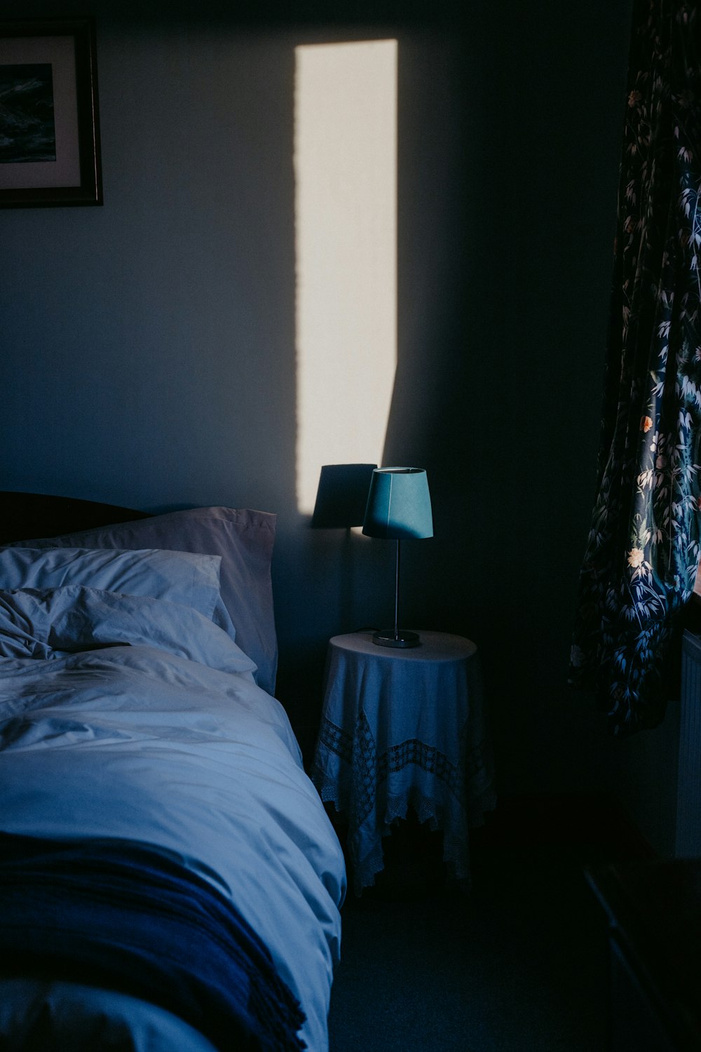 white bed linen near black and white table lamp