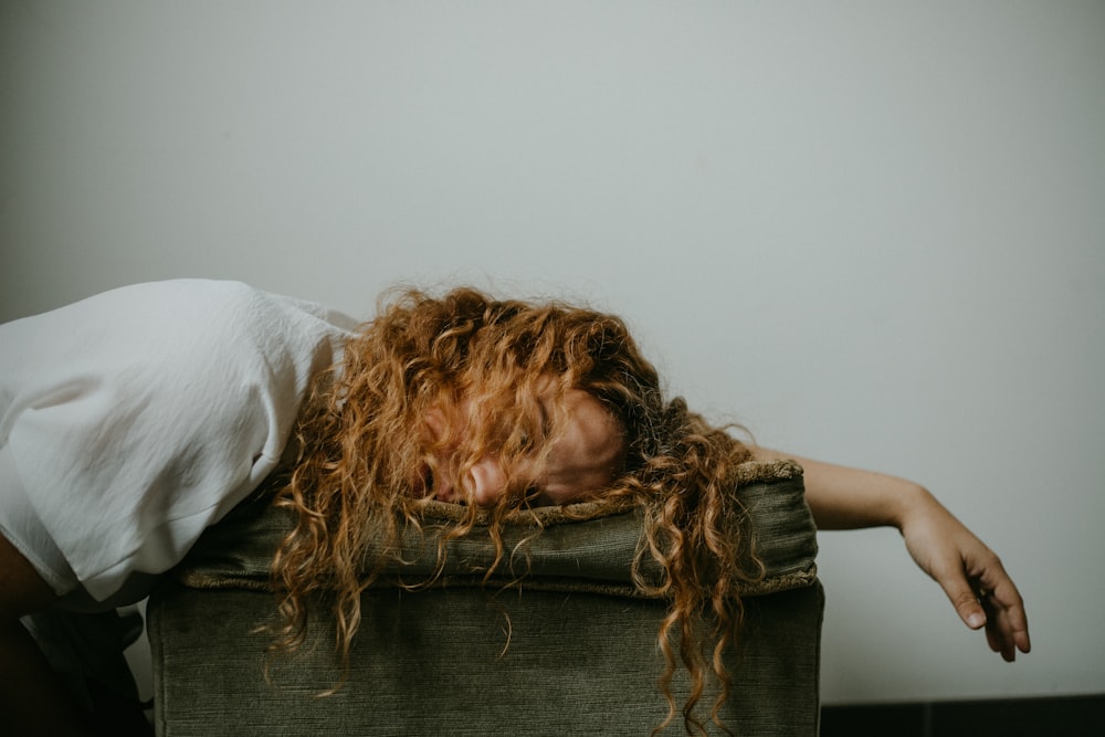 woman in white shirt lying on black textile