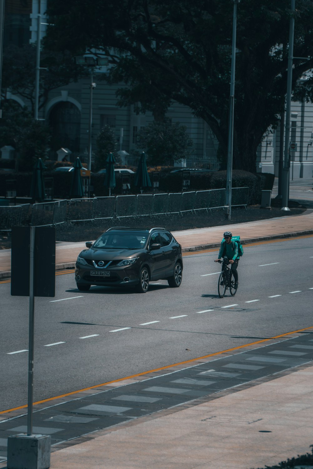 Hombre en chaqueta negra montando en bicicleta en la carretera durante el día