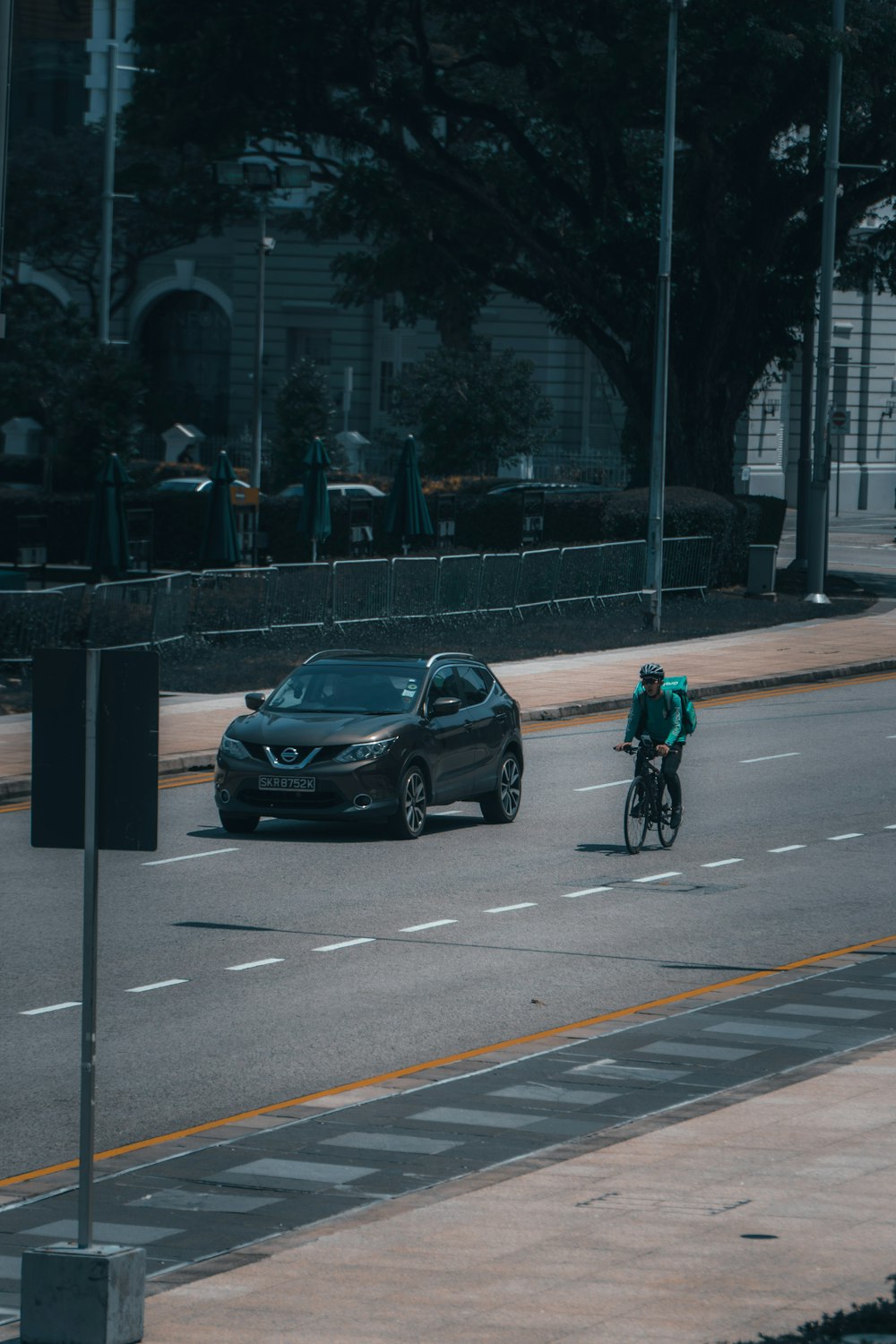 man in black jacket riding bicycle on road during daytime