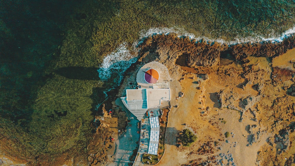 aerial view of white and brown house on brown sand beach during daytime