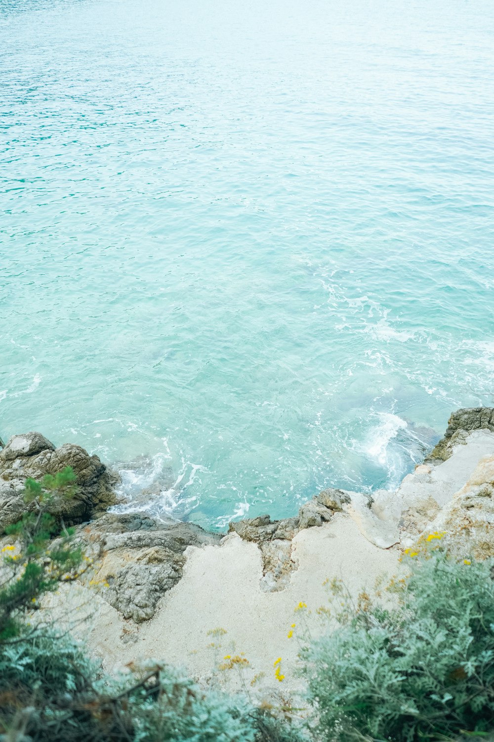 body of water near brown rocks during daytime