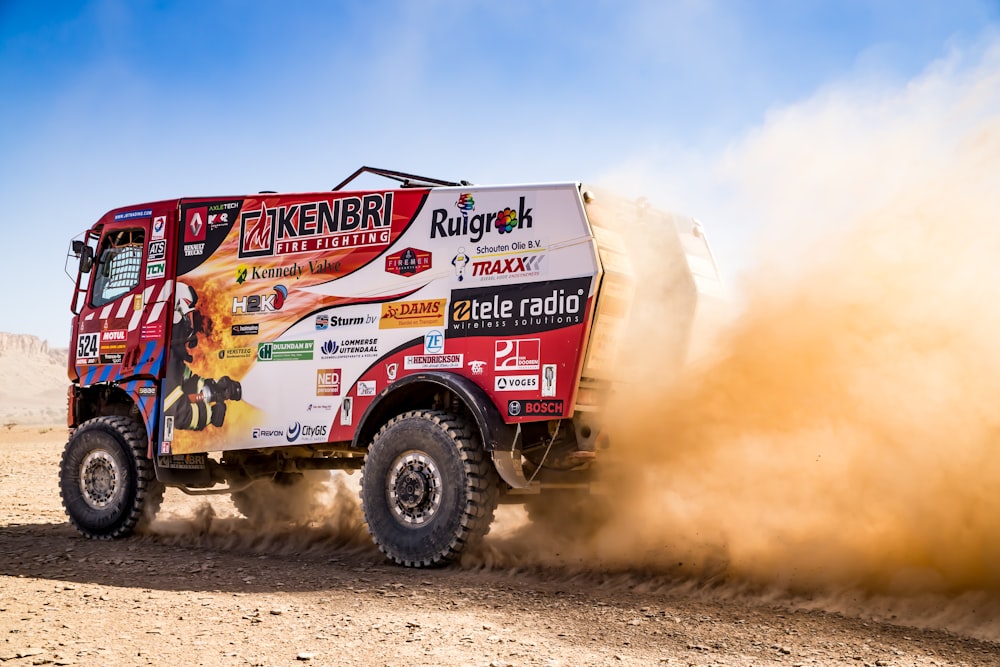 red and yellow truck on brown sand during daytime