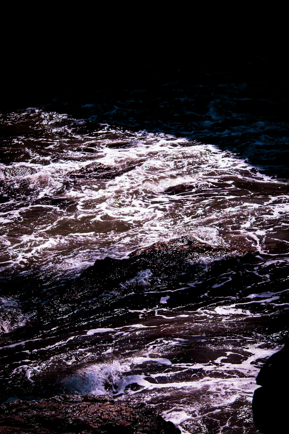 Wasserwellen, die tagsüber auf Felsen treffen