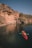 Young woman kayaking in a serene Norwegian fjord surrounded by towering cliffs.