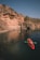 Young woman kayaking in a serene Norwegian fjord surrounded by towering cliffs.