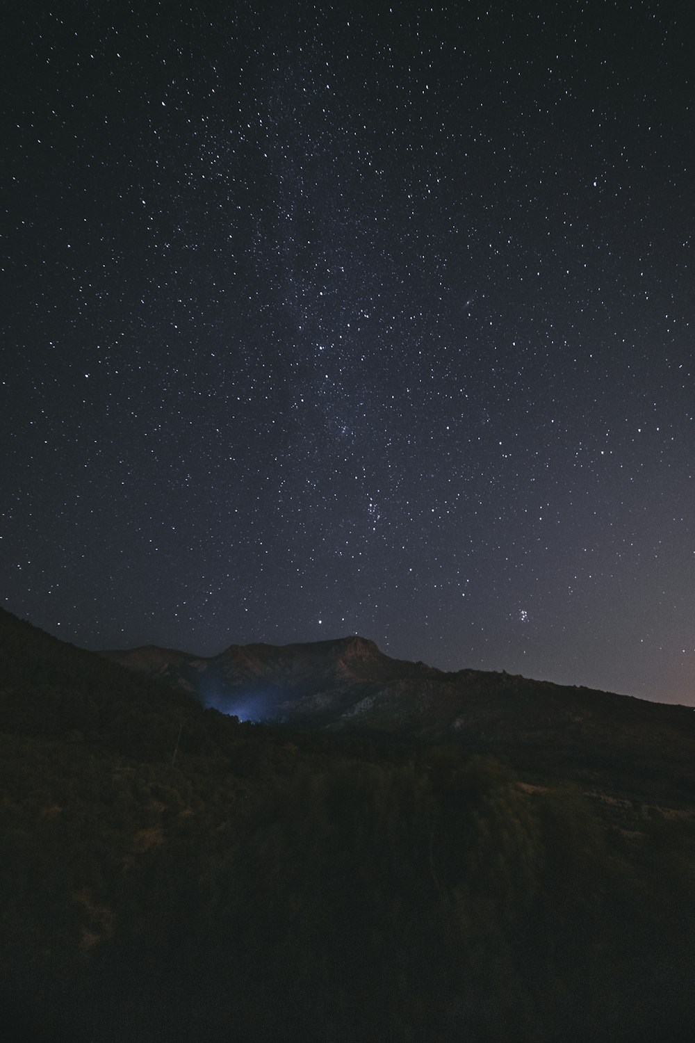 silhouette of mountain under starry night