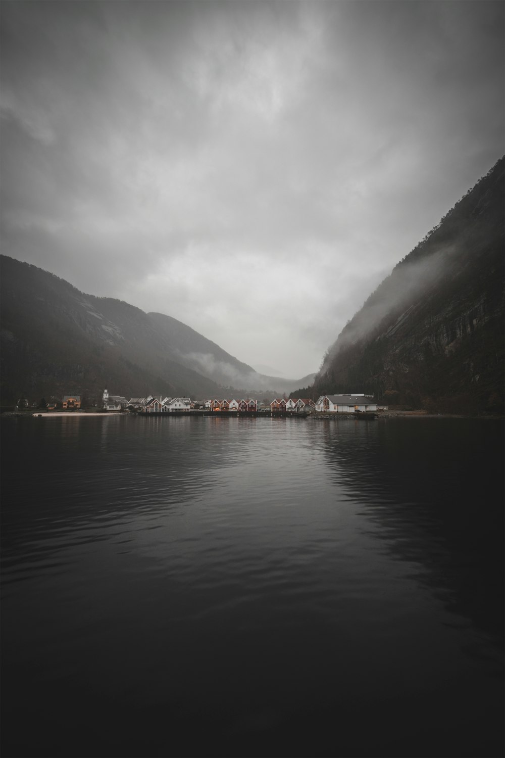 body of water near mountain during daytime