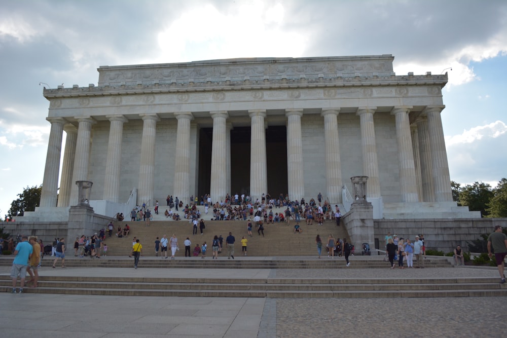 people walking around white concrete building during daytime