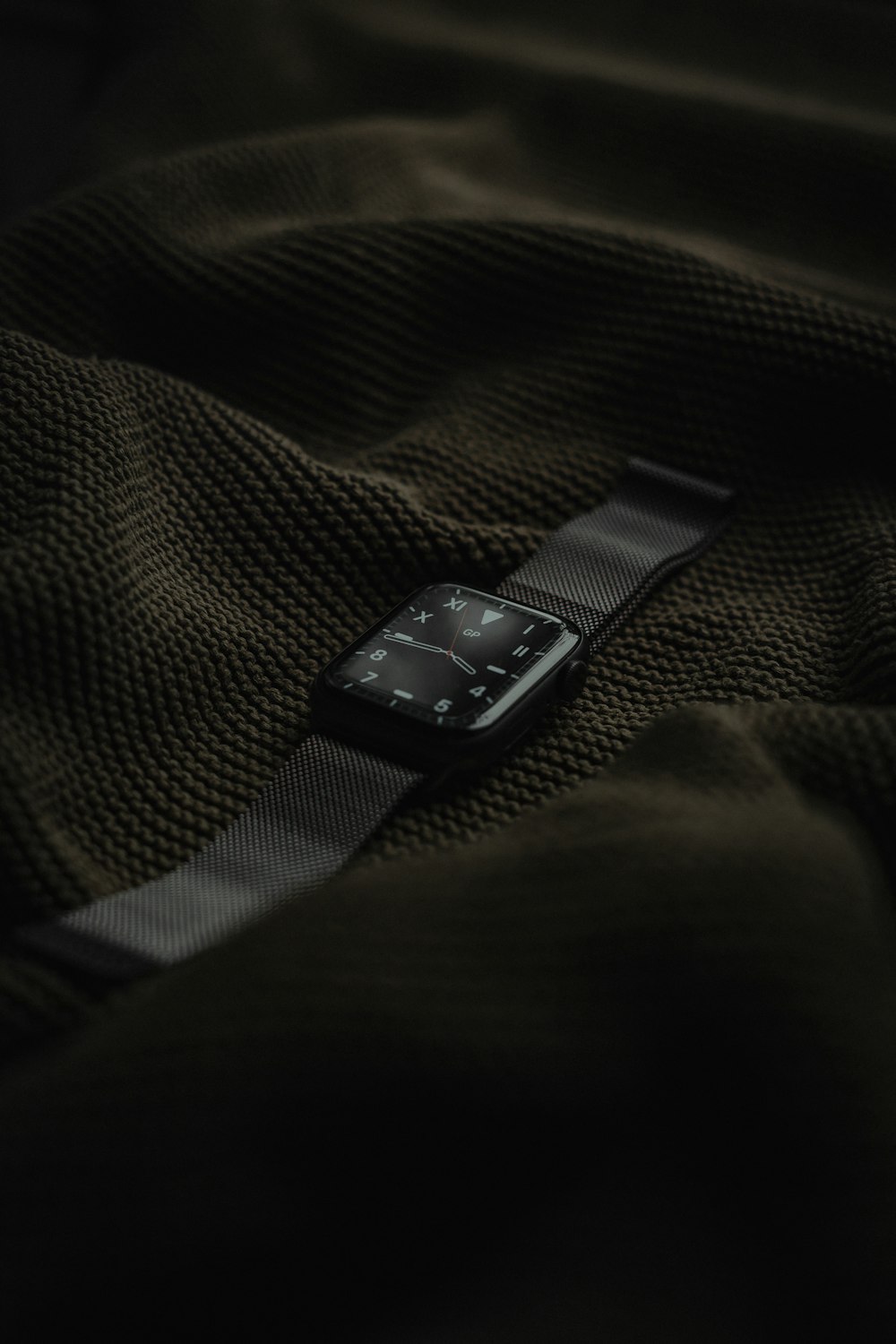black apple watch on black and gray textile