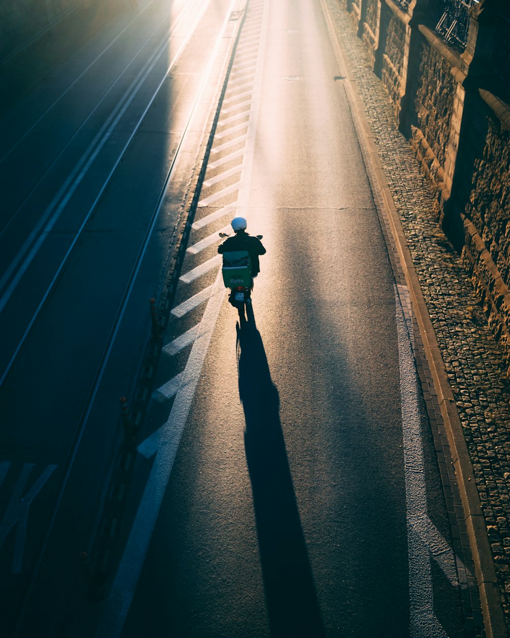 person in black jacket walking on train rail during night time