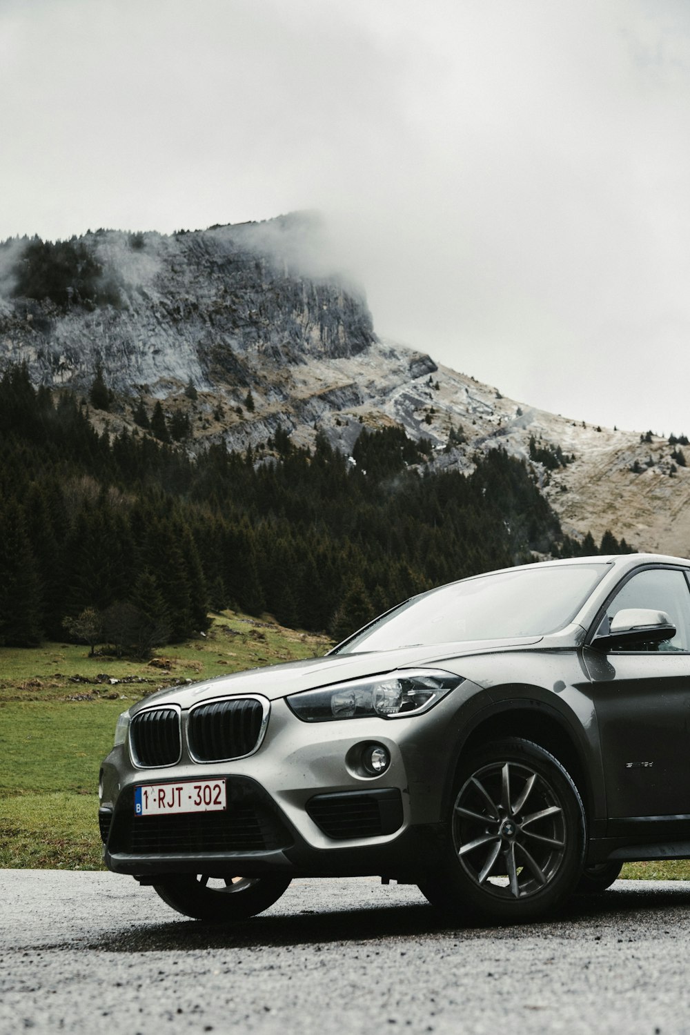 BMW M 3 nera sul campo di erba verde vicino alla montagna innevata durante il giorno