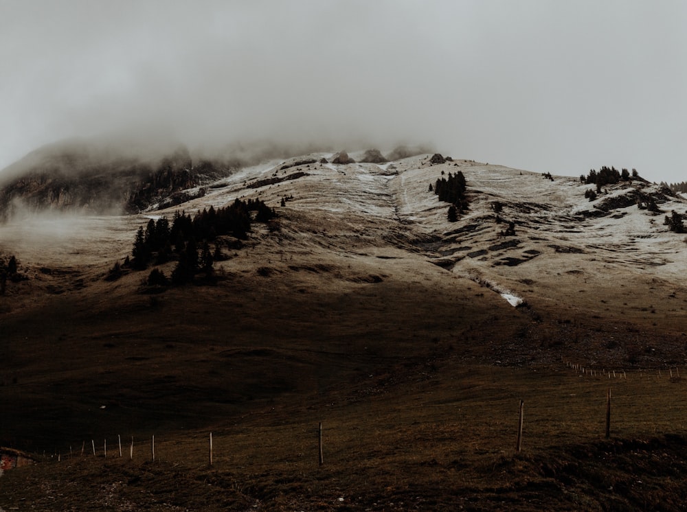 brown and white mountain under white clouds