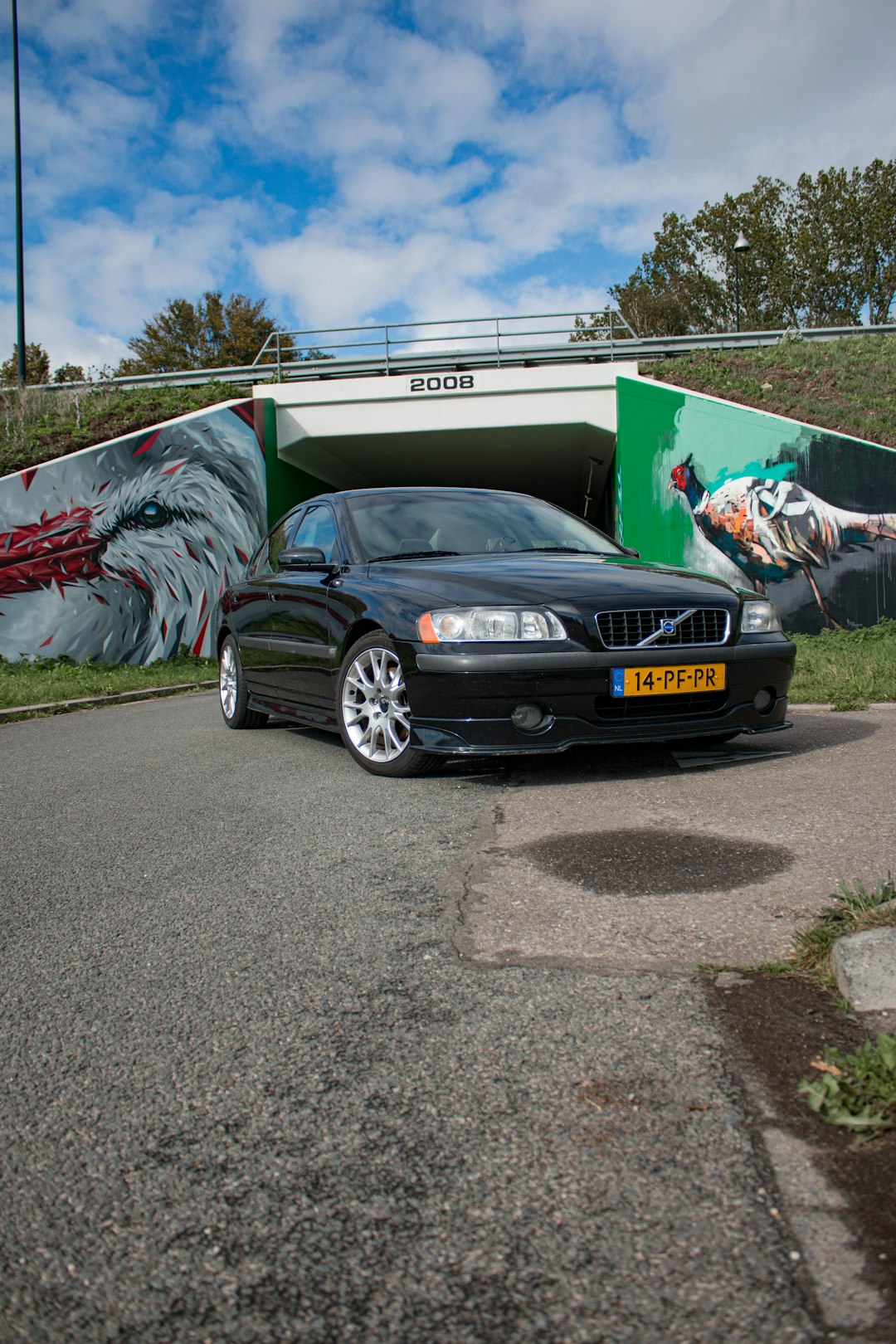 black honda car parked beside white and blue house