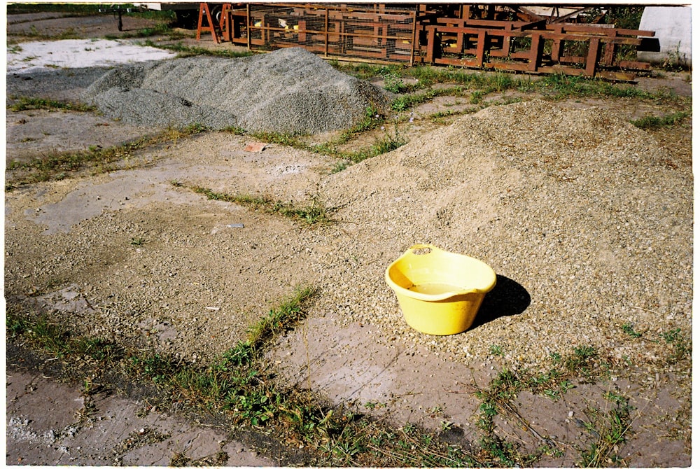 yellow plastic basin on gray concrete floor