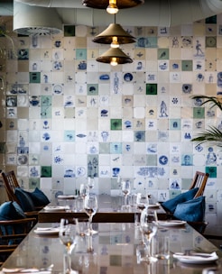 A beautifully set table in a restaurant with deep teal decor and Ottoman design elements.
