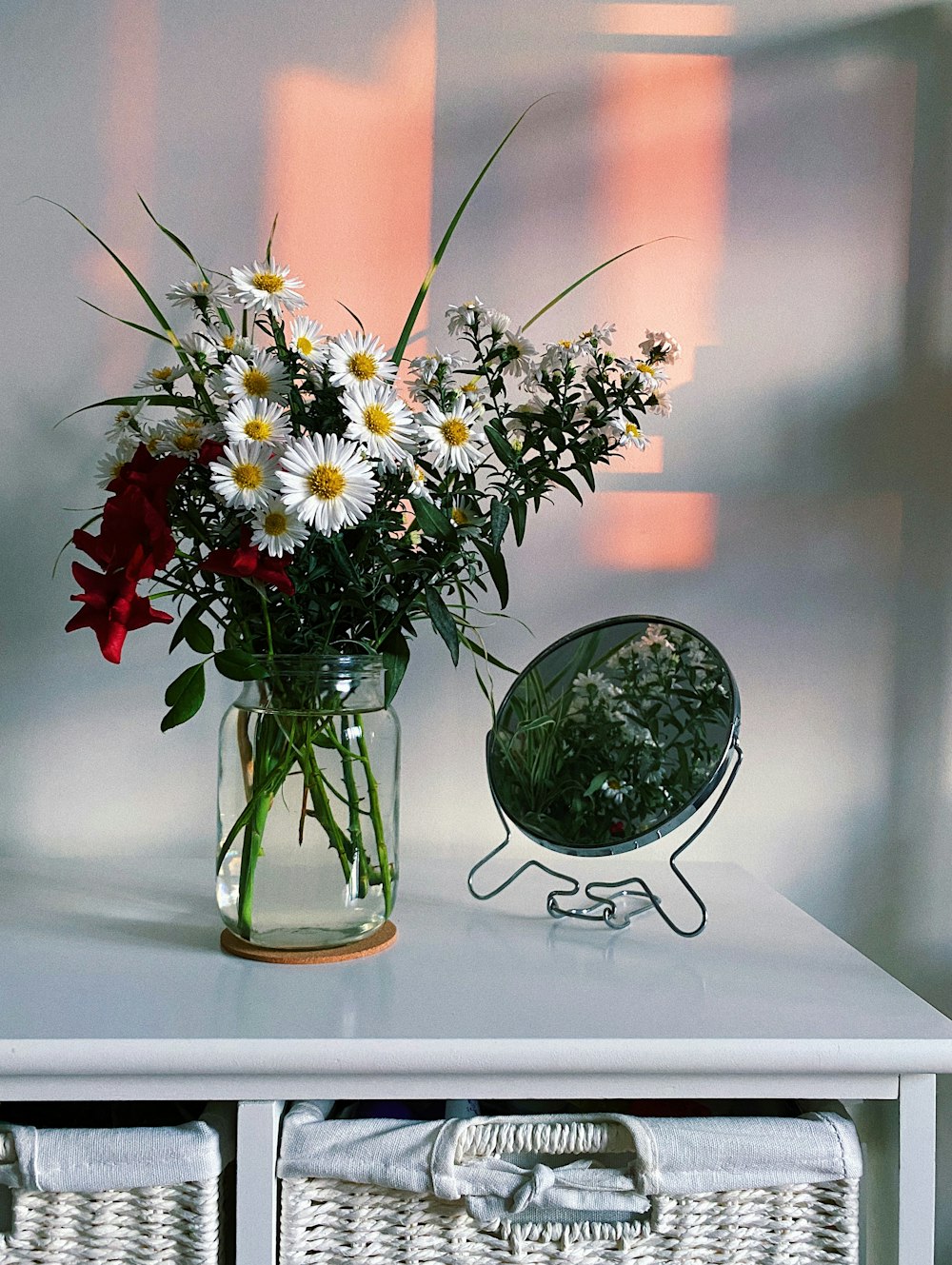 white and red flowers in clear glass vase