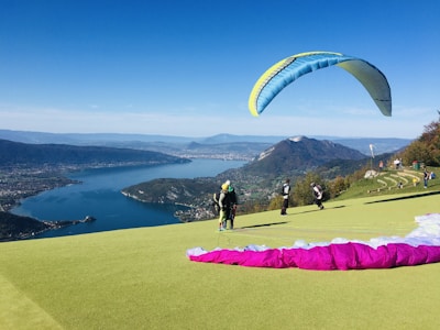 man in black shirt and black pants holding pink and yellow parachute