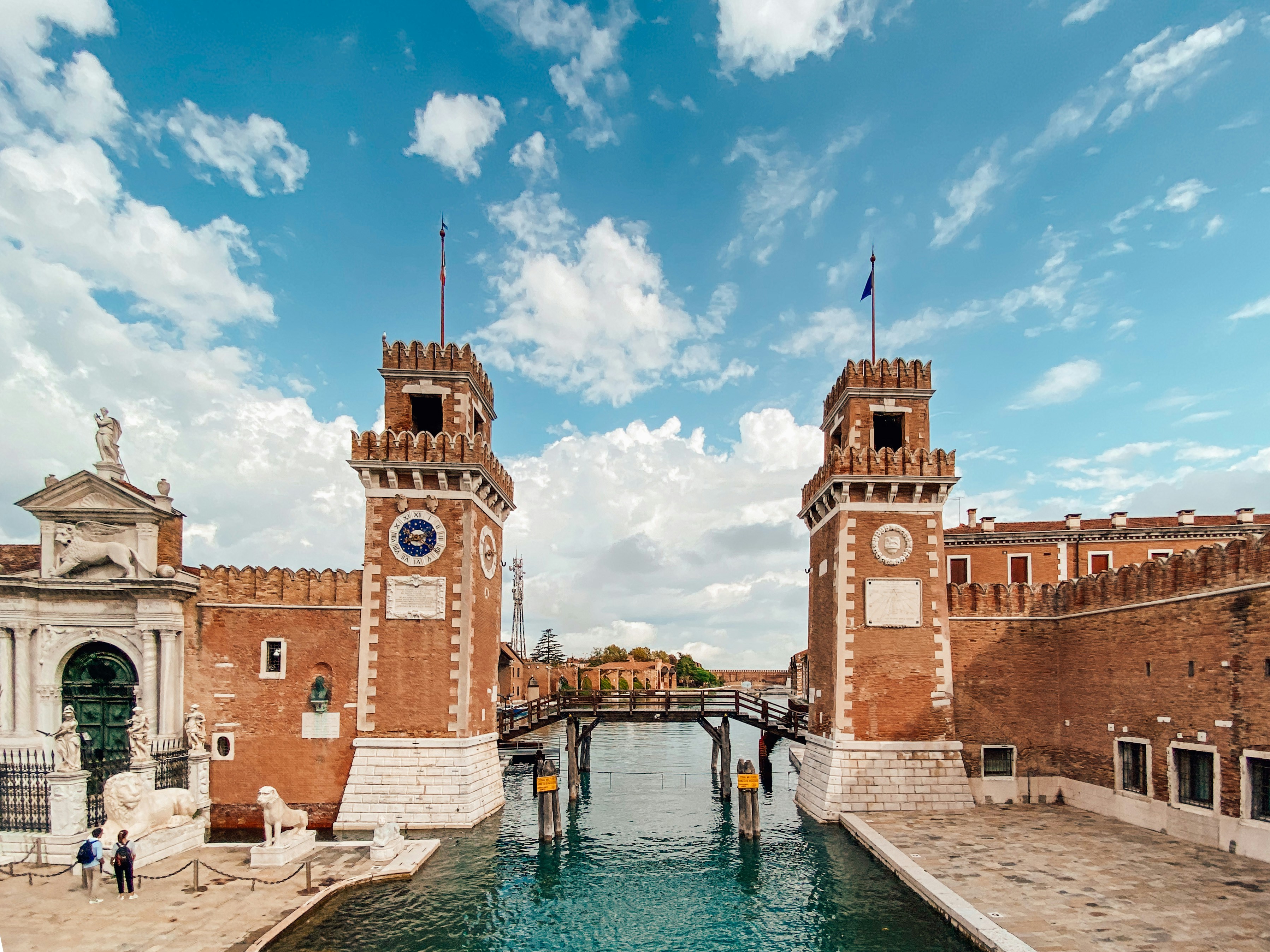 brown concrete building near body of water under blue sky during daytime