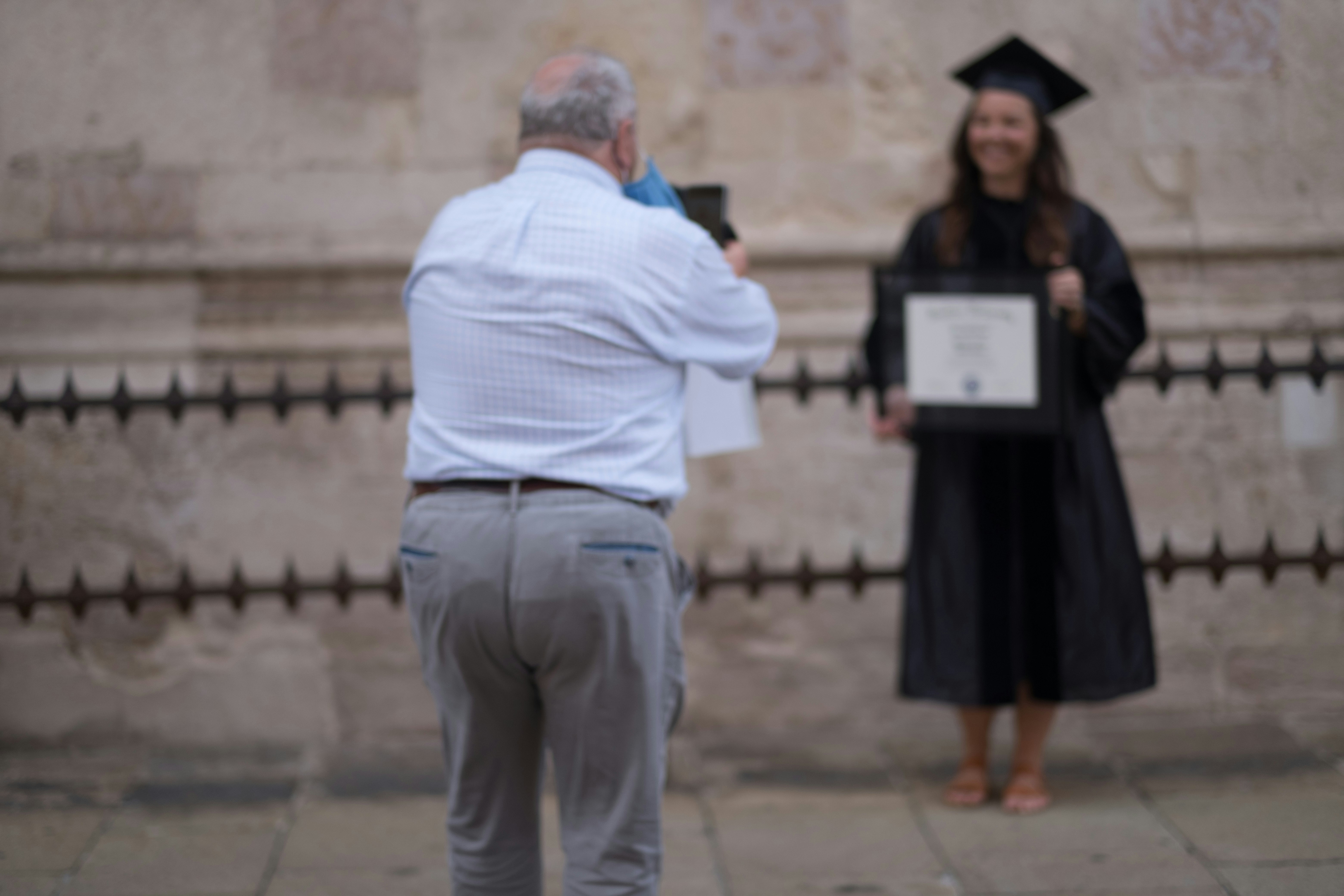 man in white dress shirt and gray pants standing on gray concrete floor during daytime