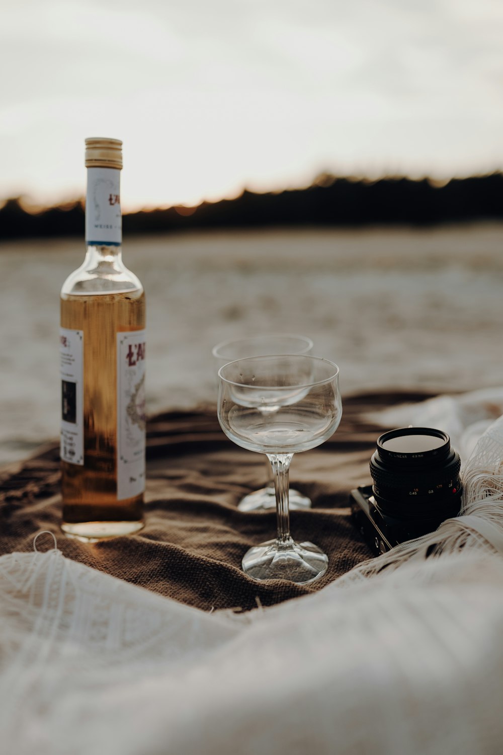 clear wine glass beside black ceramic mug on brown wooden table