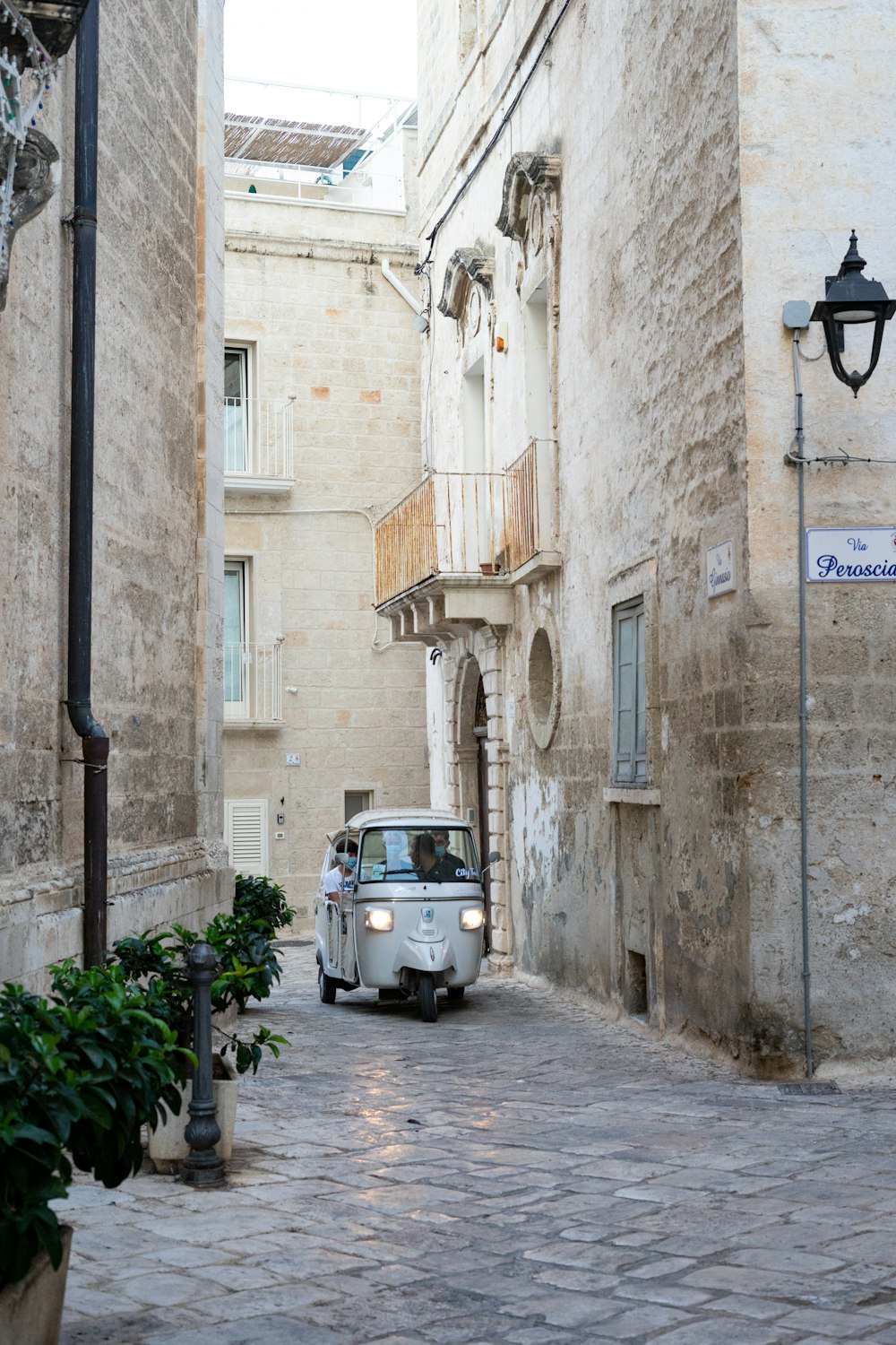 white car parked beside brown concrete building during daytime