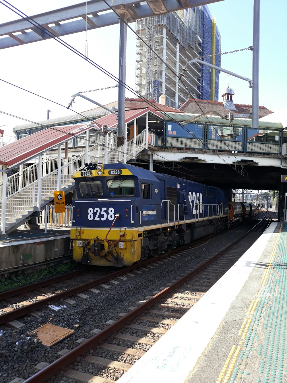 blue and yellow train on rail tracks