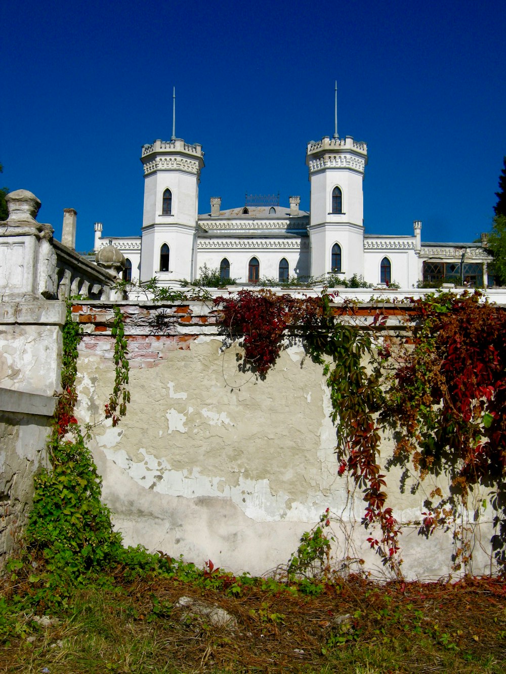 white concrete building near red leaf trees during daytime