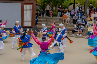 Street performers dancing to K-pop hits in a lively Seoul plaza, surrounded by curious onlookers.