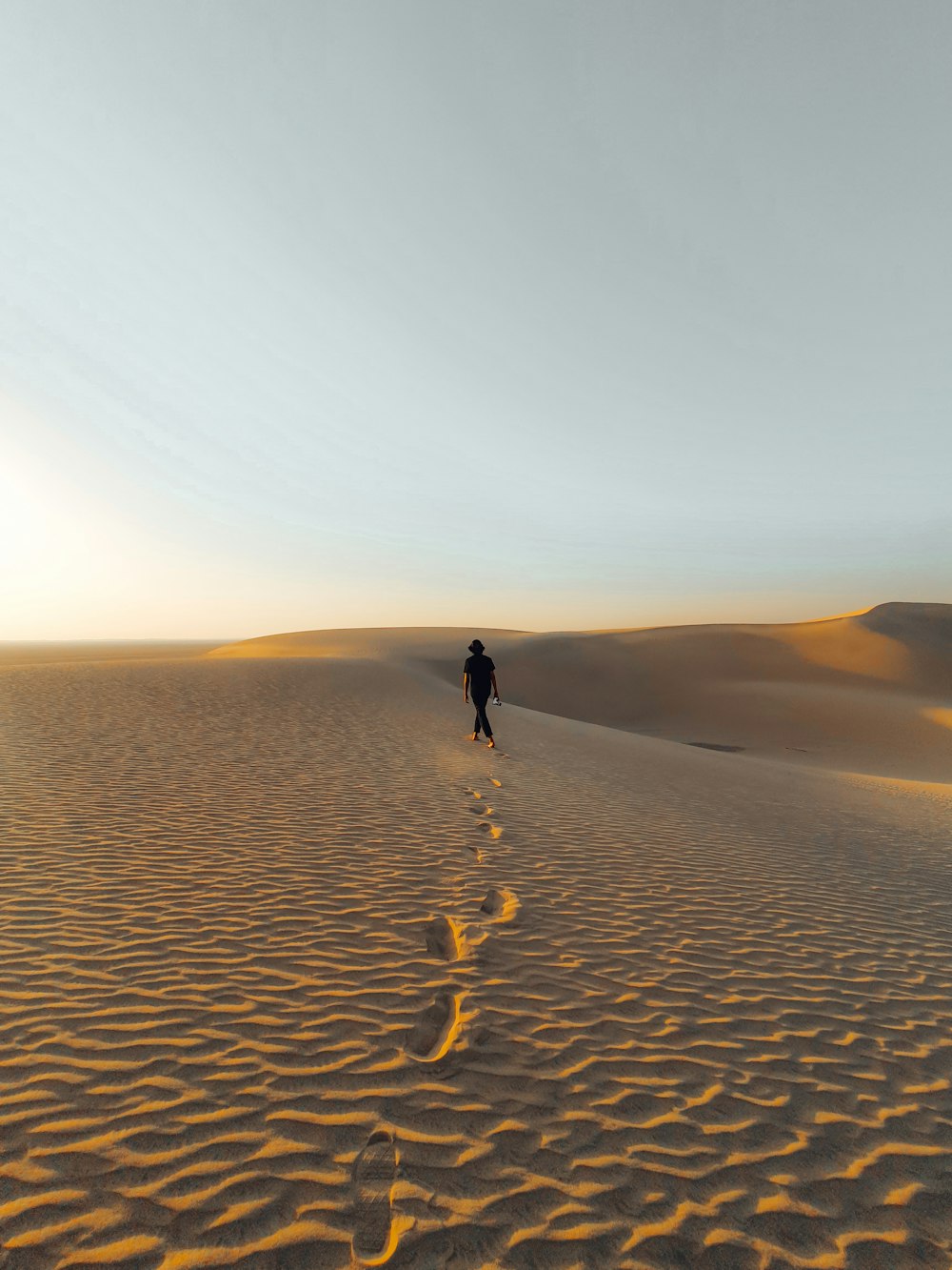 person walking on sand during daytime