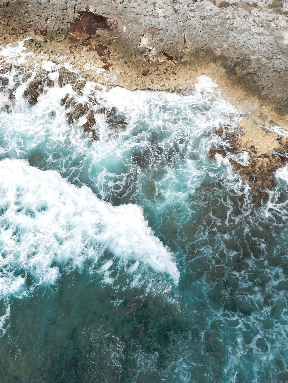 water waves hitting brown sand during daytime