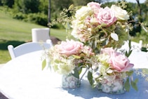 pink and white roses in white ceramic vase