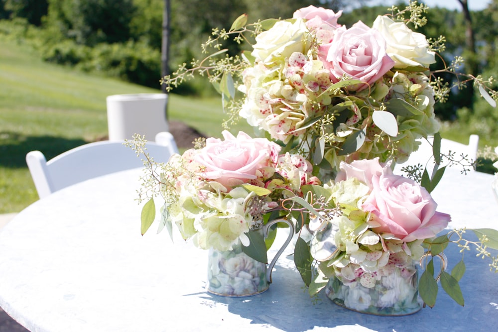 pink and white roses in white ceramic vase