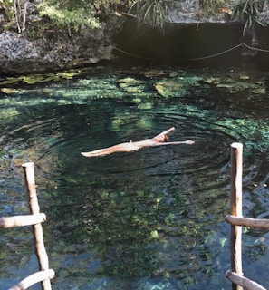 woman in black bikini swimming on water during daytime