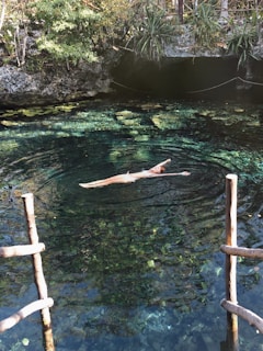 woman in black bikini swimming on water during daytime