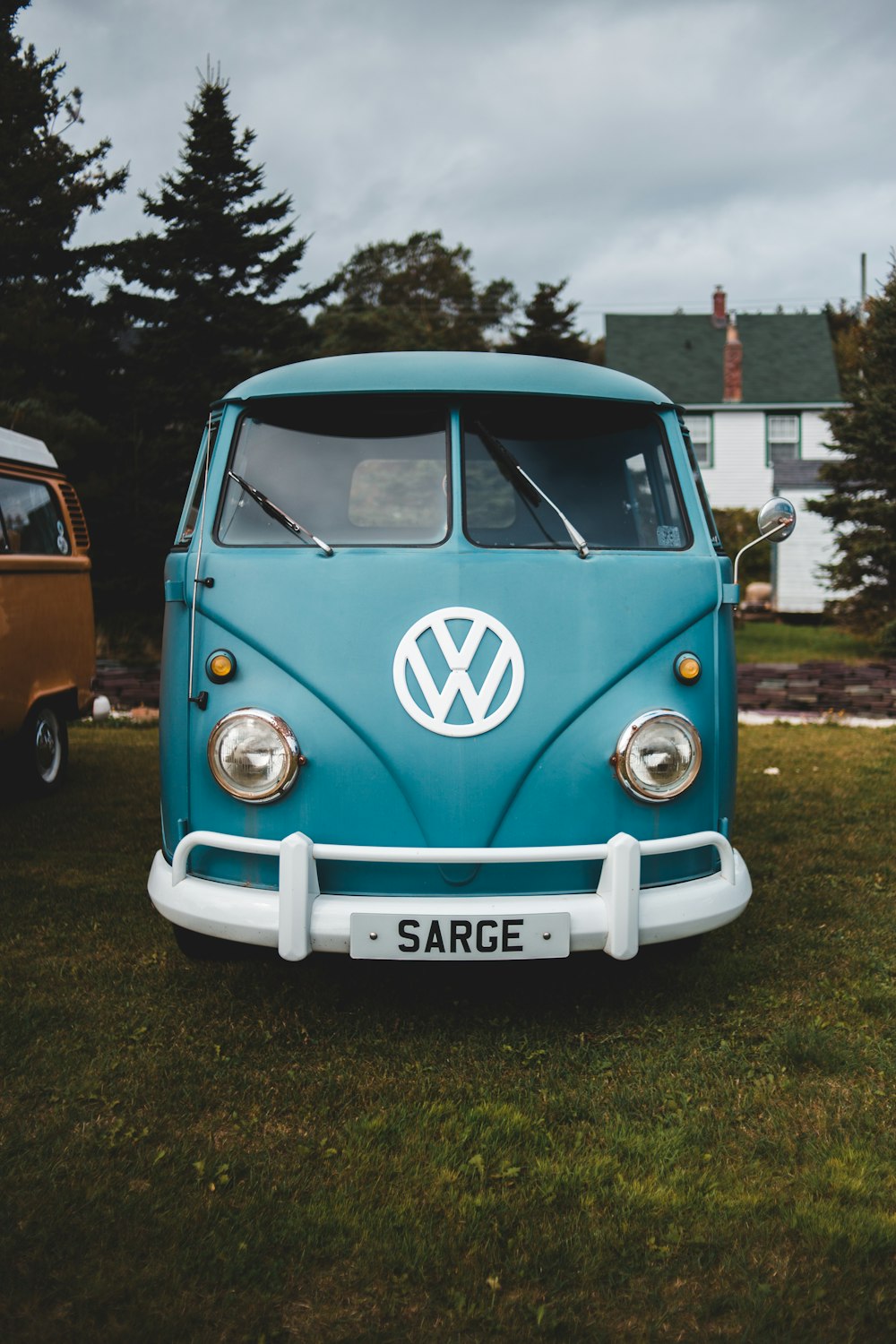 blue and white volkswagen t-2 van parked on green grass field during daytime