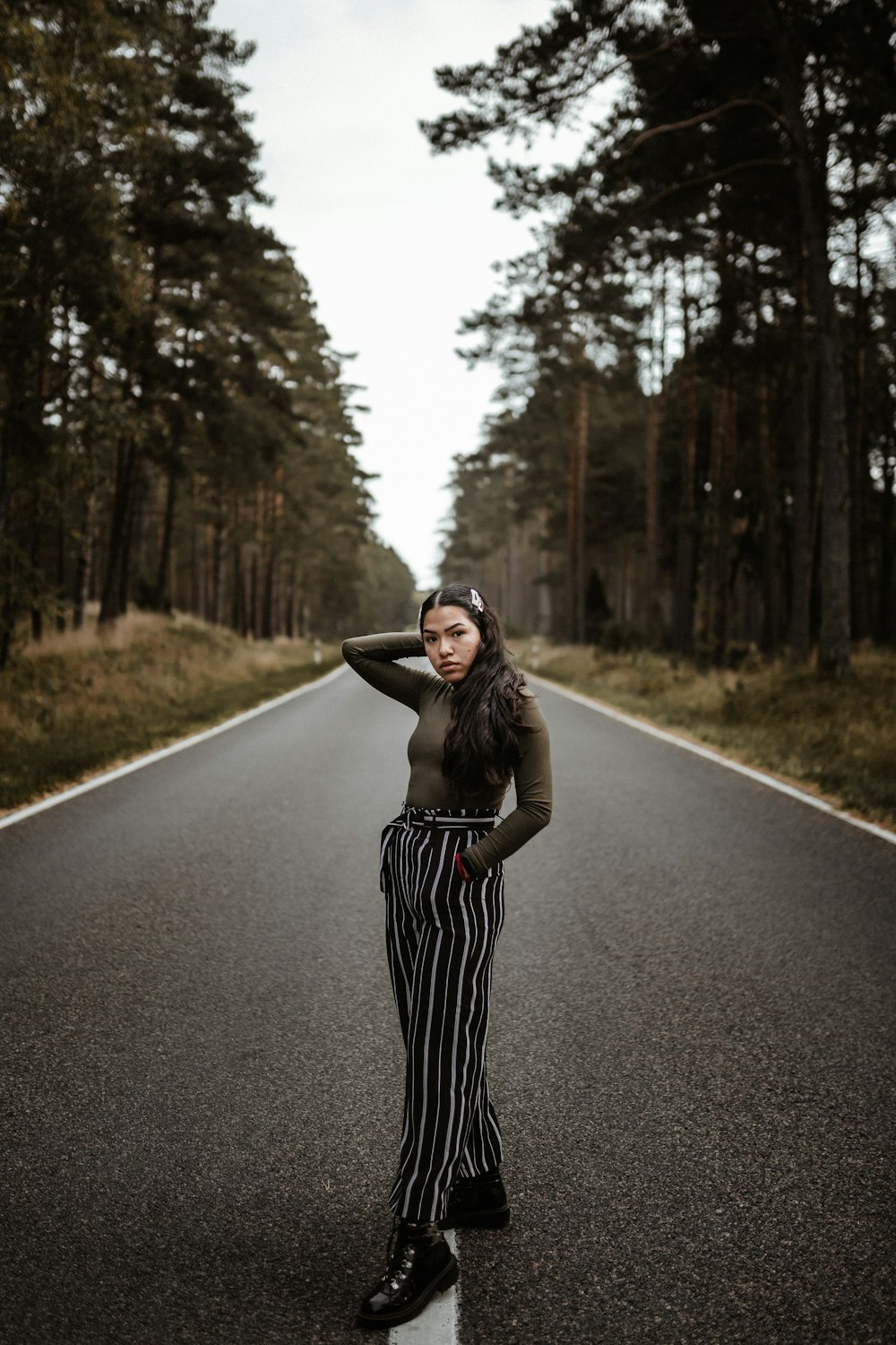woman in black and white stripe dress standing on road during daytime