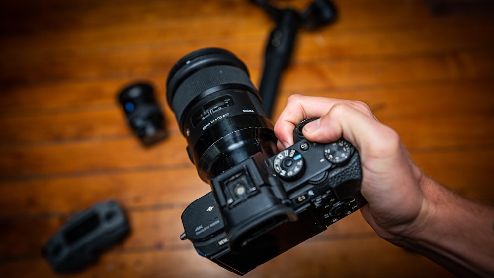 person holding black dslr camera