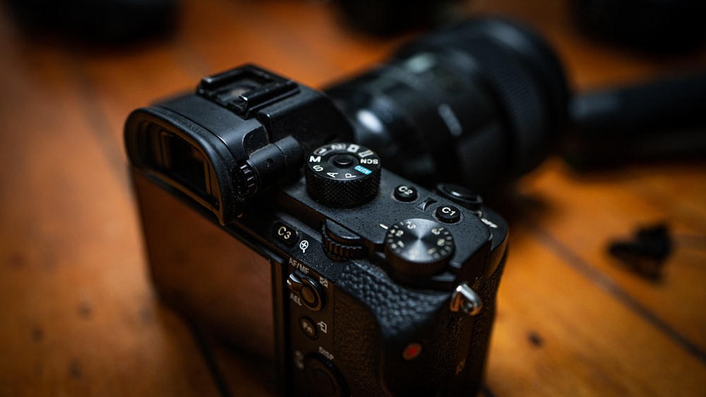 black dslr camera on brown wooden table