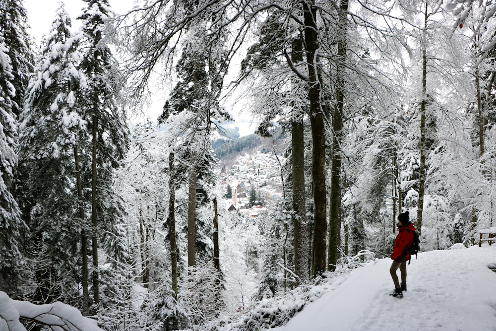 person in red jacket walking on snow covered ground