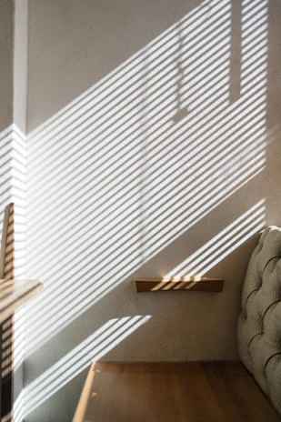Soft morning light filtering through a window onto a minimalist wellness shelf with herbal supplements.