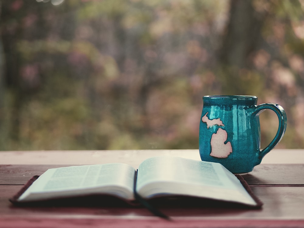 blue ceramic mug on book page